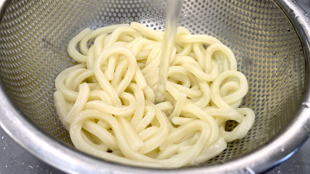 うどんを流水で洗う